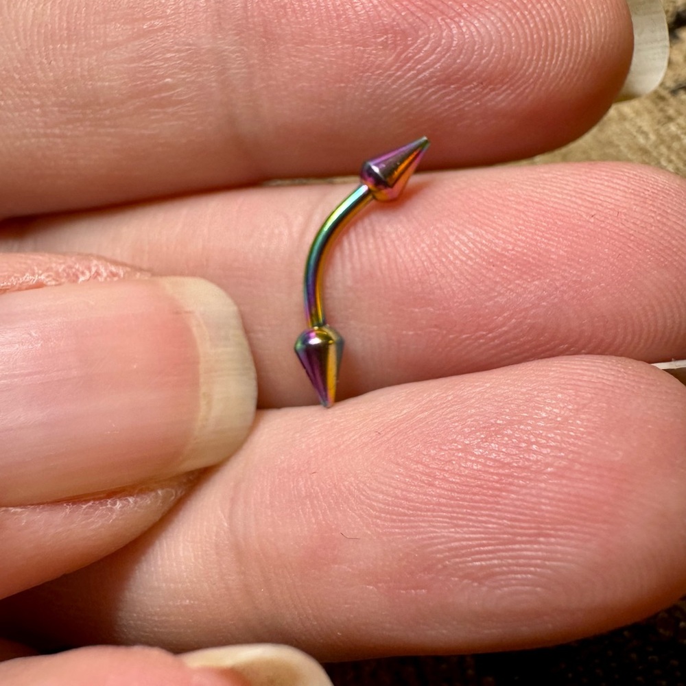 Anodized 16g curved barbell with spikes